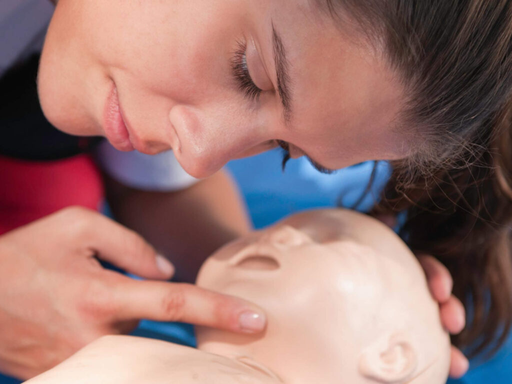 Woman practicing cpr on dummy